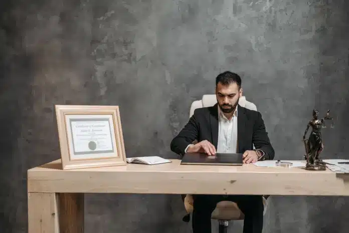 Personne consultant des documents juridiques et des preuves sur un ordinateur de bureau Personne consultant des documents juridiques et des preuves sur un ordinateur de bureau