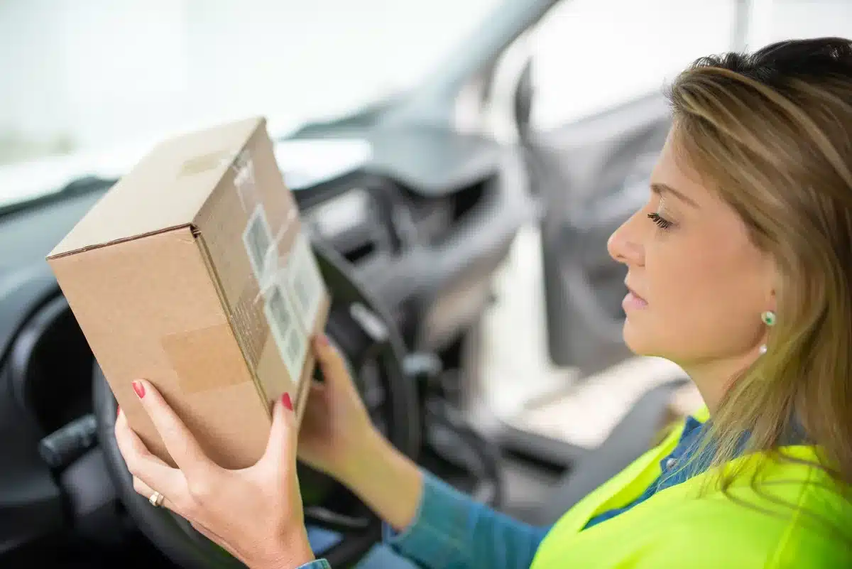 Conducteur vérifiant une adresse de livraison sur son appareil de navigation
