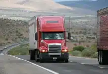 Comment un moteur d’optimisation de tournées réduit-il les temps de conduite ? Camion de livraison en circulation urbaine avec affichage de l'itinéraire optimisé sur le tableau de bord