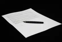 Divorce sans contrat de mariage : quels risques pour votre patrimoine ? Mains tenant un document déchiré symbolisant la séparation des biens, avec dossiers financiers en arrière-plan