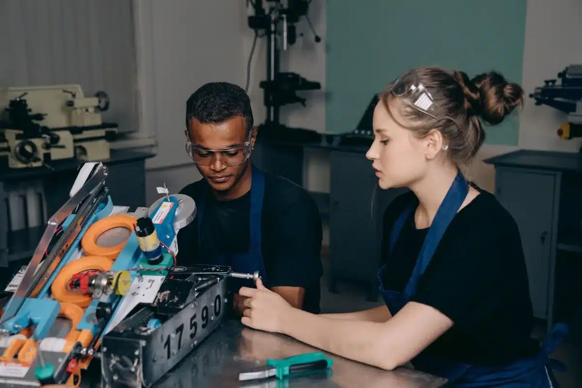 Jeune en alternance travaillant en entreprise aux côtés d'un professionnel