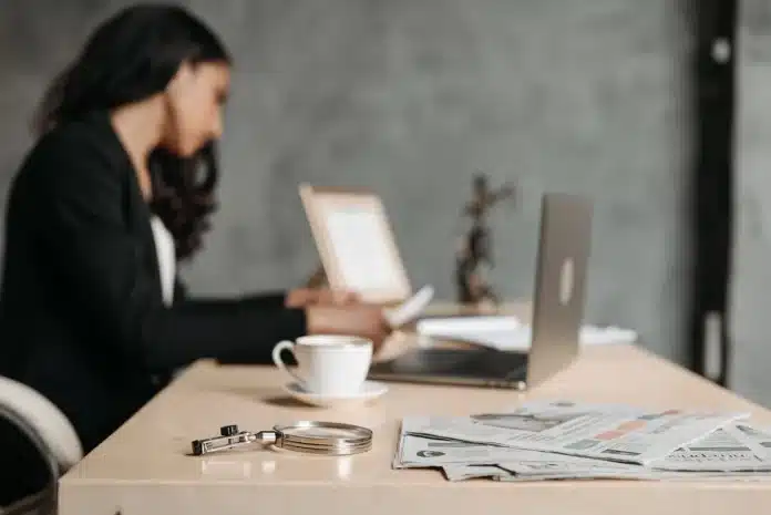 Mains tenant un portefeuille vide et un formulaire de plainte auprès de la police, documents éparpillés sur un bureau Mains tenant un portefeuille vide et un formulaire de plainte auprès de la police, documents éparpillés sur un bureau