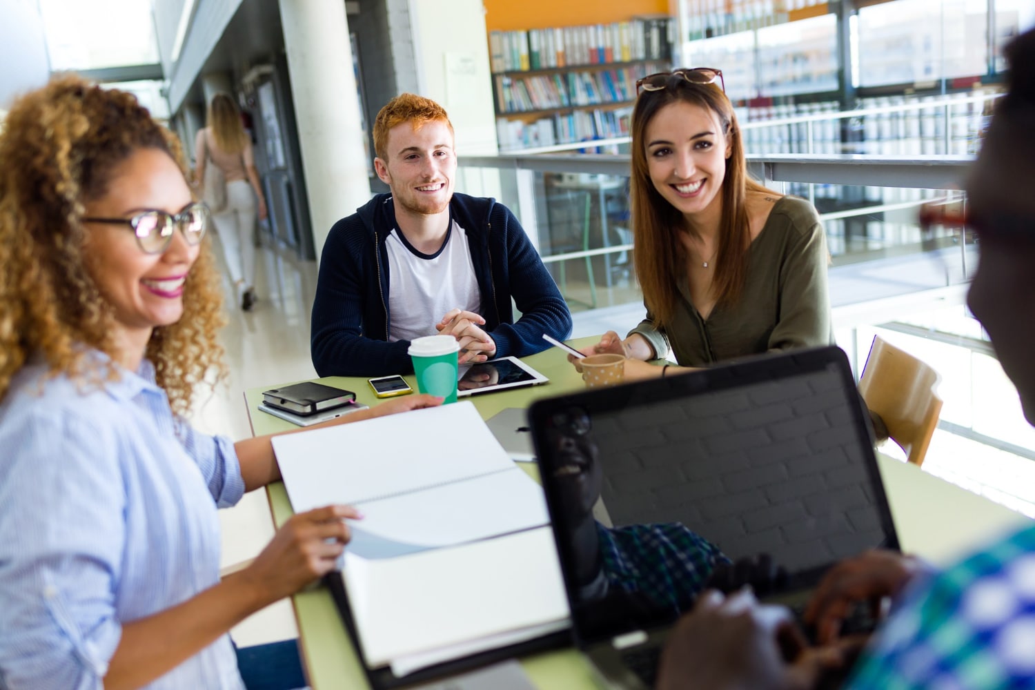 Portrait d'un groupe d'amis étudiant dans une bibliothèque universitaire.