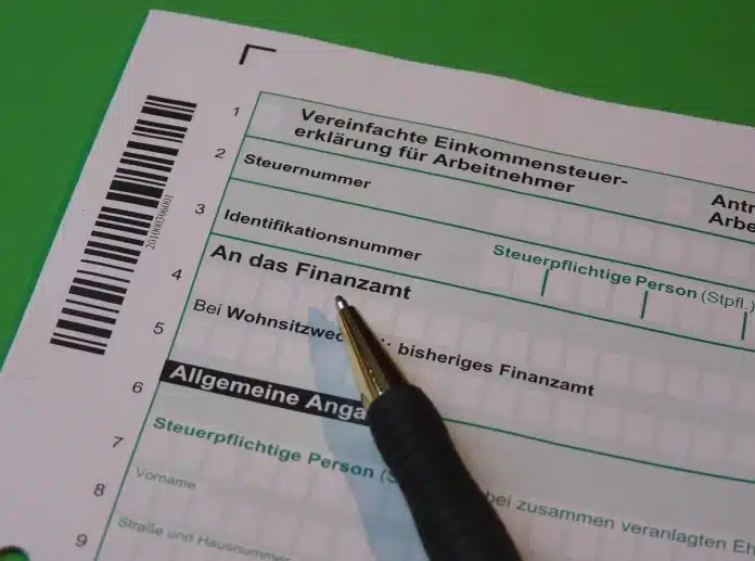 Enveloppe officielle et documents fiscaux sur un bureau avec ordinateur Enveloppe officielle et documents fiscaux sur un bureau avec ordinateur
