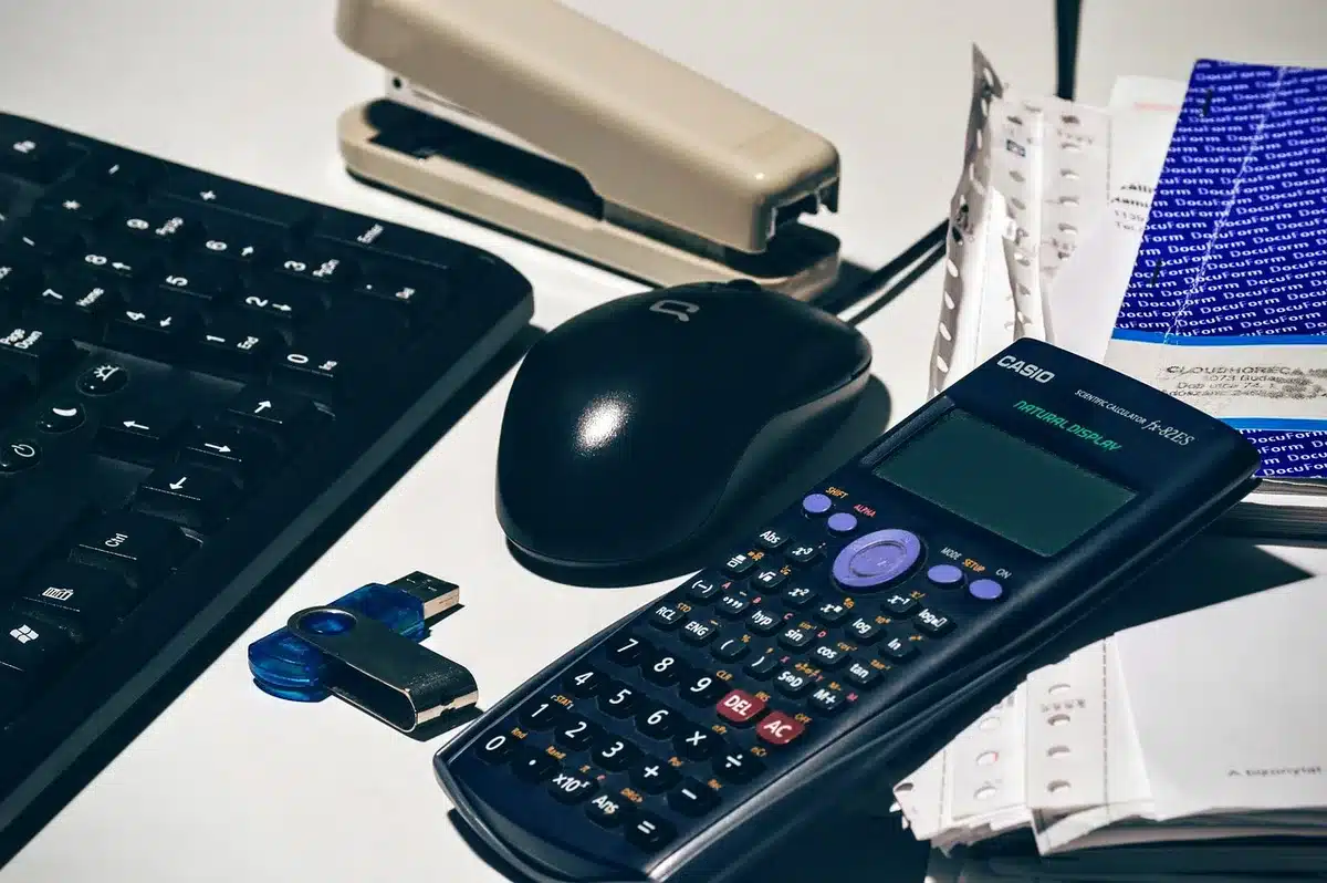 Fiches de paie et calculatrice sur un bureau en lumière du jour