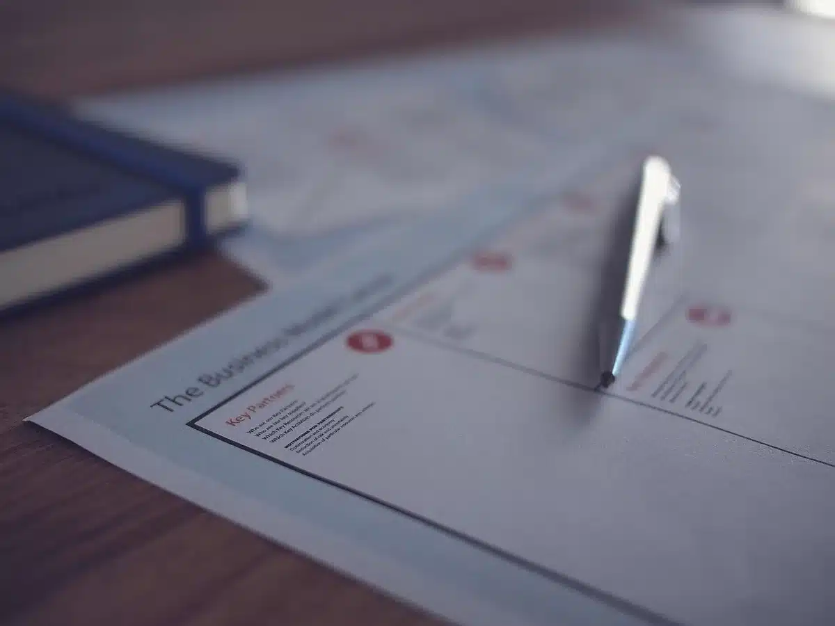 Personne rédigeant une attestation sur une feuille avec un stylo
