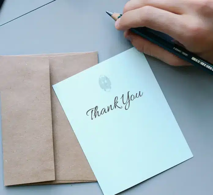 Mains anonymes triant des papiers administratifs sur un bureau avec une enveloppe et des lunettes Mains anonymes triant des papiers administratifs sur un bureau avec une enveloppe et des lunettes