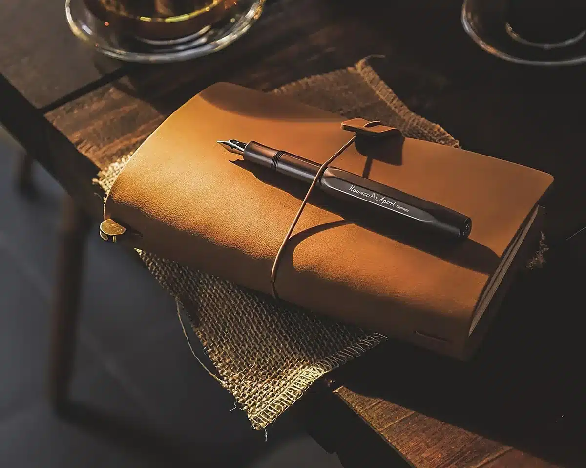 Carnet ouvert avec checklist, calculatrice et ordinateur portable sur un bureau en journée