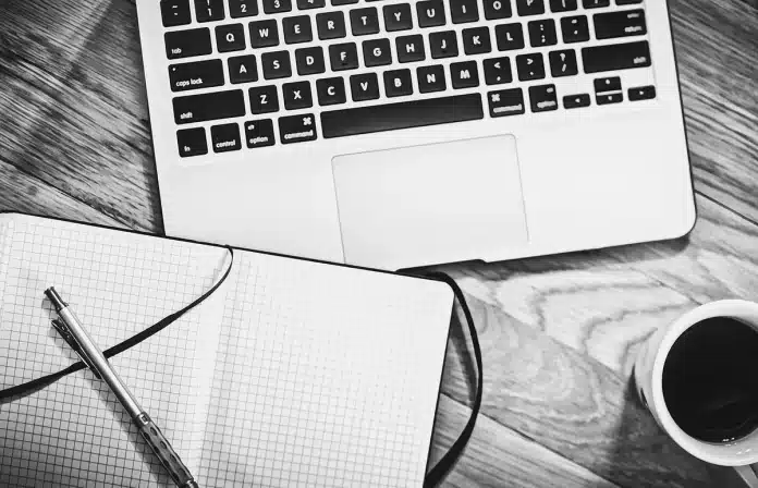 Espace de travail avec ordinateur portable, bloc-notes et café pour préparer une boutique en ligne Espace de travail avec ordinateur portable, bloc-notes et café pour préparer une boutique en ligne