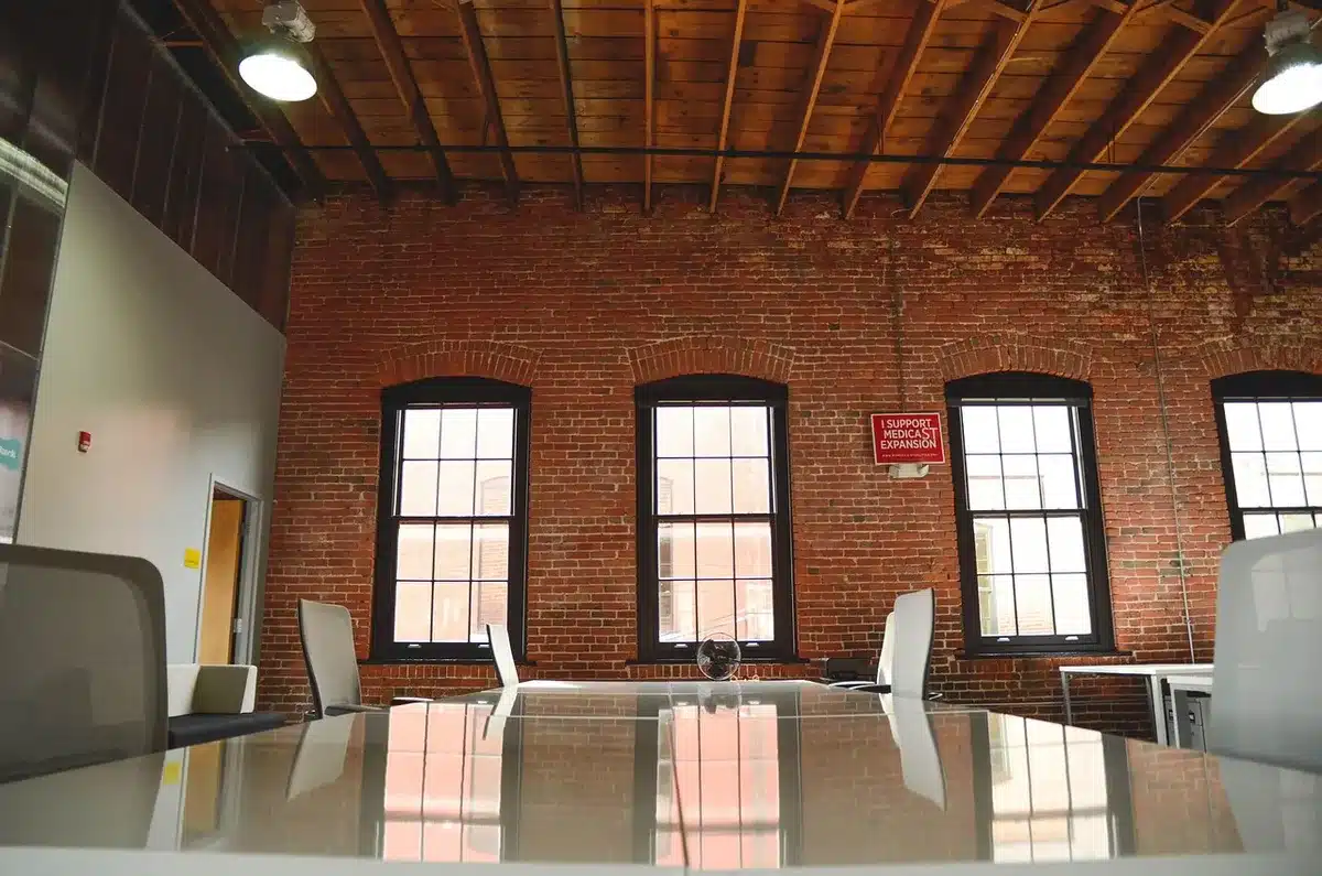 Anonymous small group of entrepreneurs around a table, laptops and notebooks visible, engaged in discussion