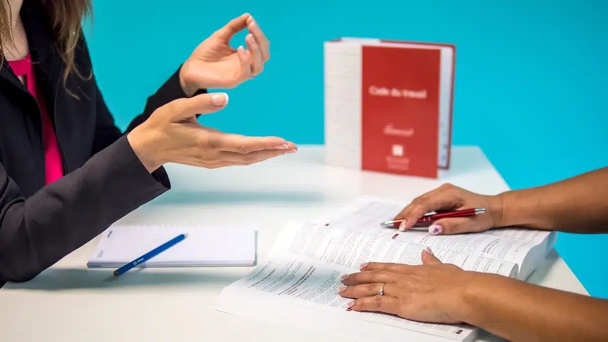 Contrat de travail posé sur un bureau avec un calendrier indiquant des dates