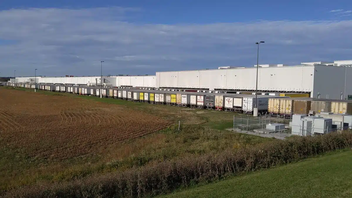 Camion de messagerie chargé dans un dépôt avec palettes et chariot