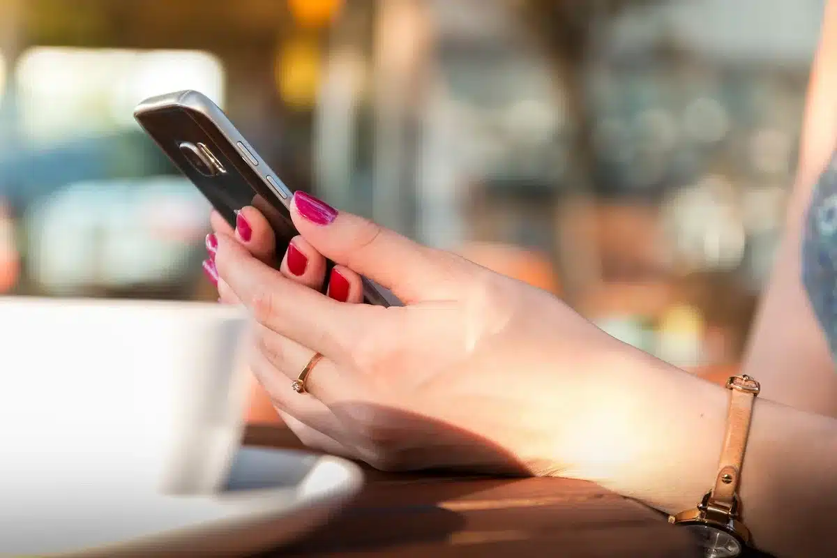 Prise de vue produit avec smartphone et fiches produit sur une table