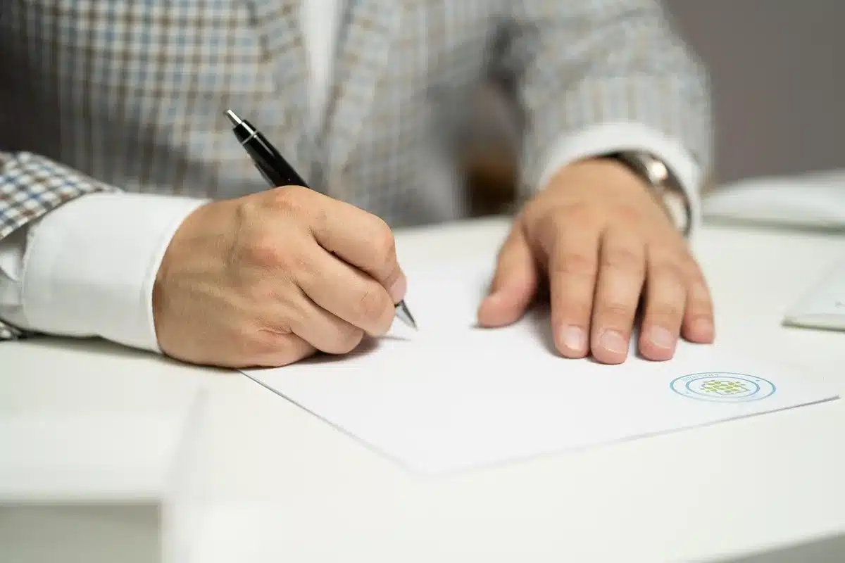 Gros plan sur une signature au bas d'un contrat dans un bureau ensoleillé