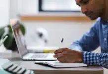 Huit niches de produits à forte marge à vendre en 2026 Bureau en journée avec ordinateur affichant une fiche produit et mains en train de travailler