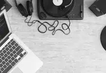 MVP : le podcast hebdomadaire sur le SEO et le référencement local Bureau en journée avec carnet, casque et ordinateur portable pour écouter un podcast SEO