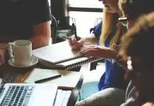 Optimiser vos campagnes de fin d’année en un prompt avec Positive User Bureau lumineux avec ordinateur, calendrier mural et post‑it pour planifier une campagne