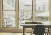 Que faire si le bénéficiaire d’une assurance-vie est décédé ? Mains anonymes et documents d'assurance vie sur un bureau lumineux près d'une fenêtre
