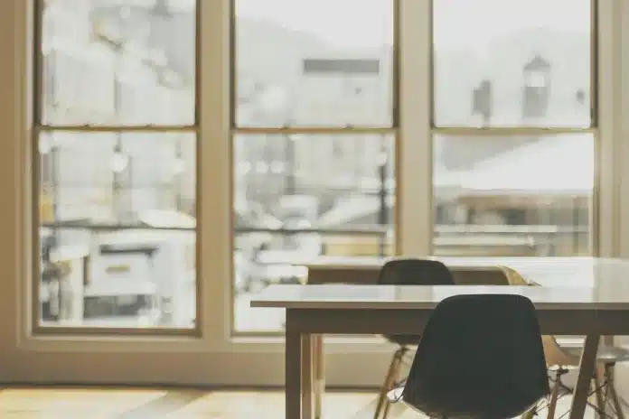Mains anonymes et documents d'assurance vie sur un bureau lumineux près d'une fenêtre Mains anonymes et documents d'assurance vie sur un bureau lumineux près d'une fenêtre