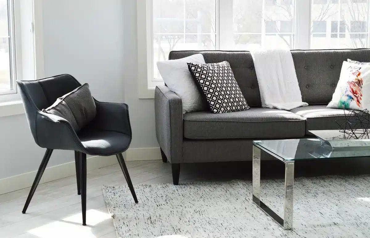 Main pointant un plan d'appartement posé sur une table pour évaluer l'attractivité