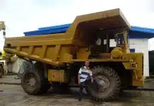Transport de granulats en carrière : réduire coûts, améliorer sécurité et productivité Camions en file près d’un pont-bascule et opérateur avec tablette en plein jour