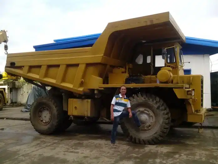 Camions en file près d’un pont-bascule et opérateur avec tablette en plein jour Camions en file près d’un pont-bascule et opérateur avec tablette en plein jour
